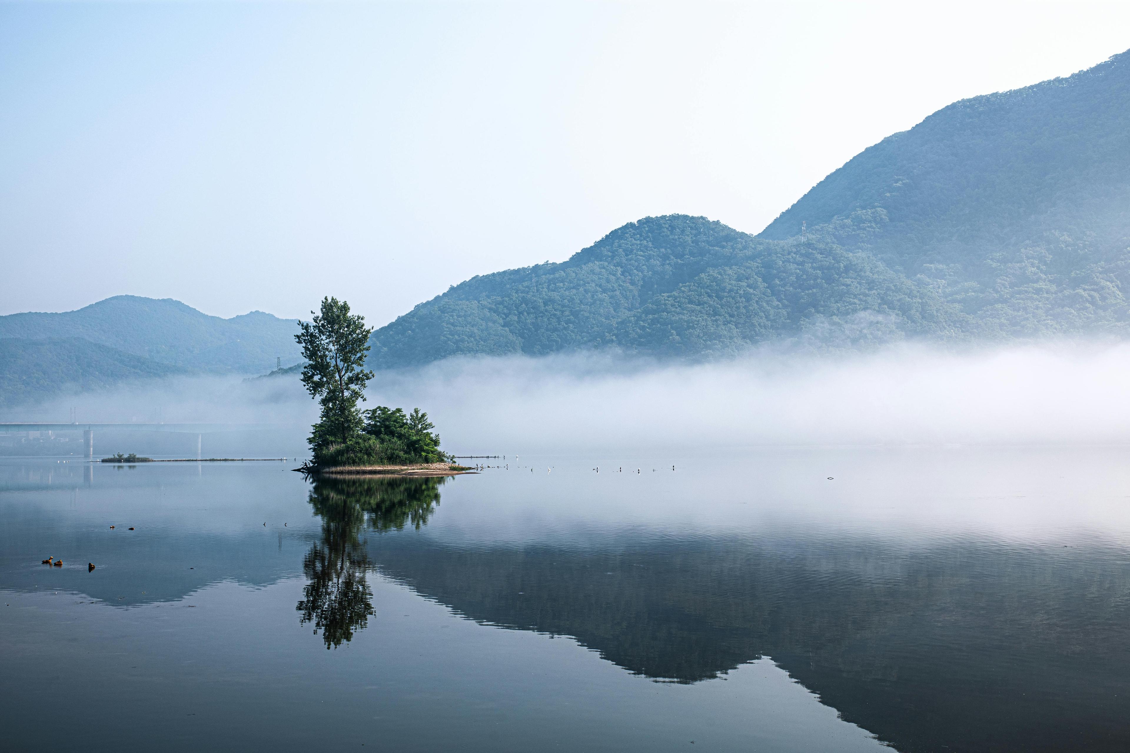 Serene island reflection in a misty lake with mountains in Gapyeong South Korea