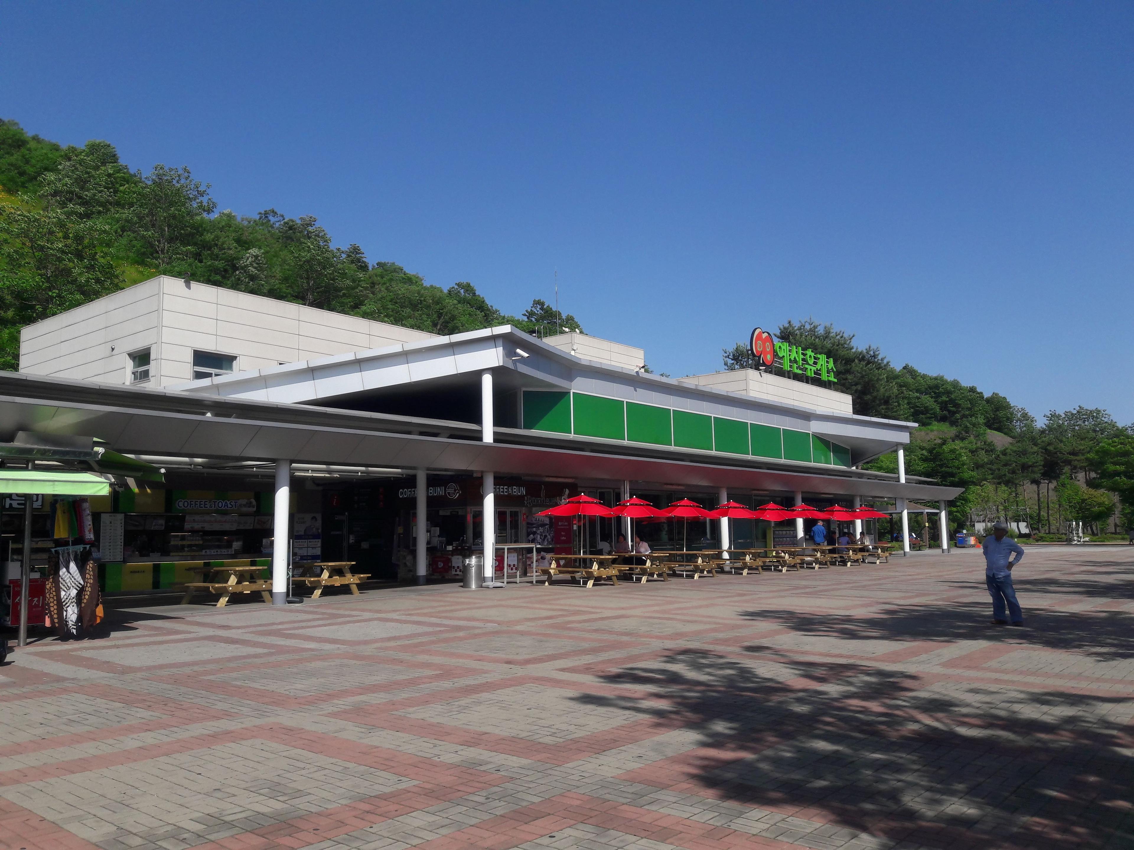 Yesan rest area on a Korean expressway with parked cars and main facility building