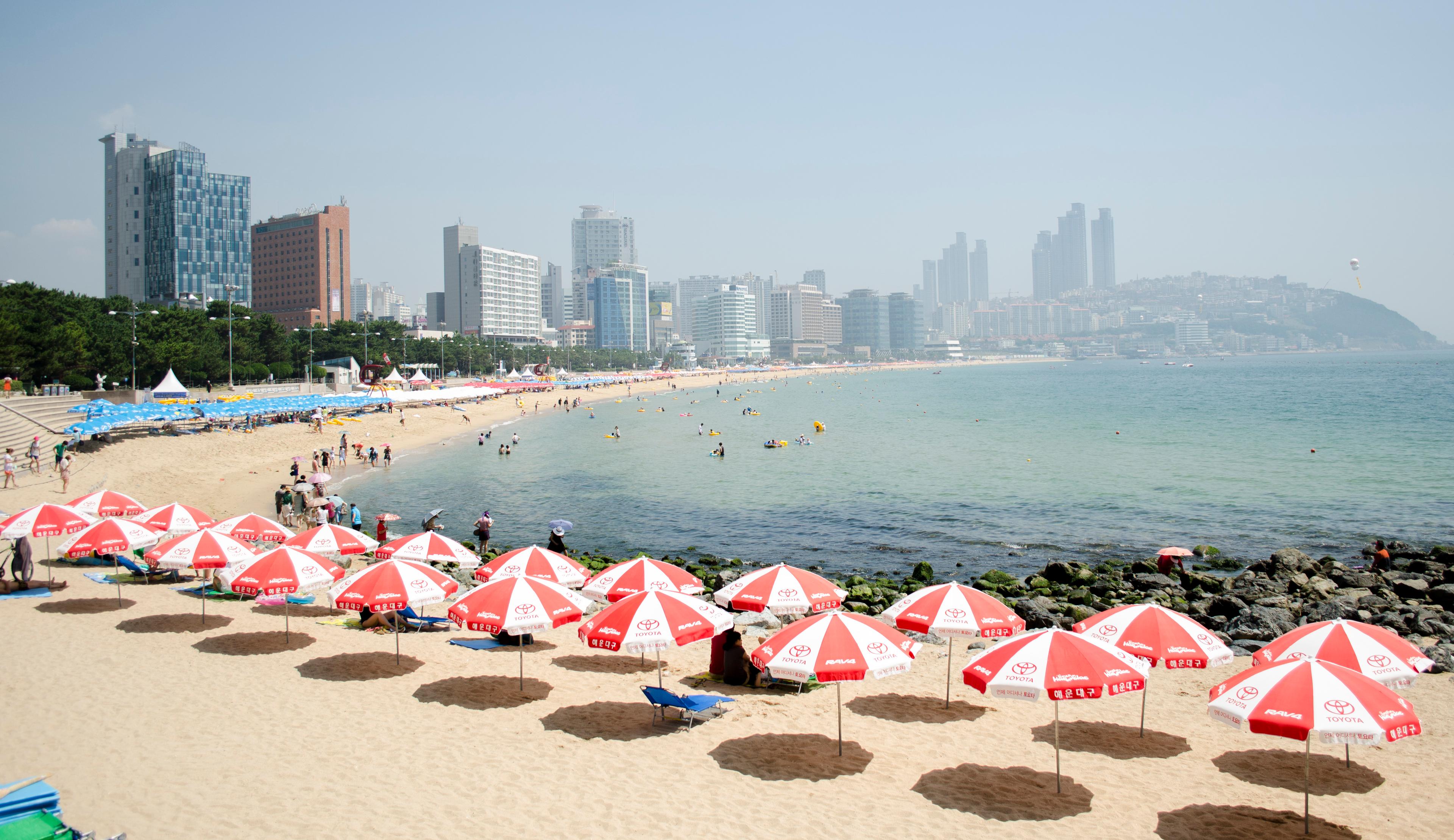 Haeundae Beach in Busan, Korea at golden hour with city skyline behind the sand