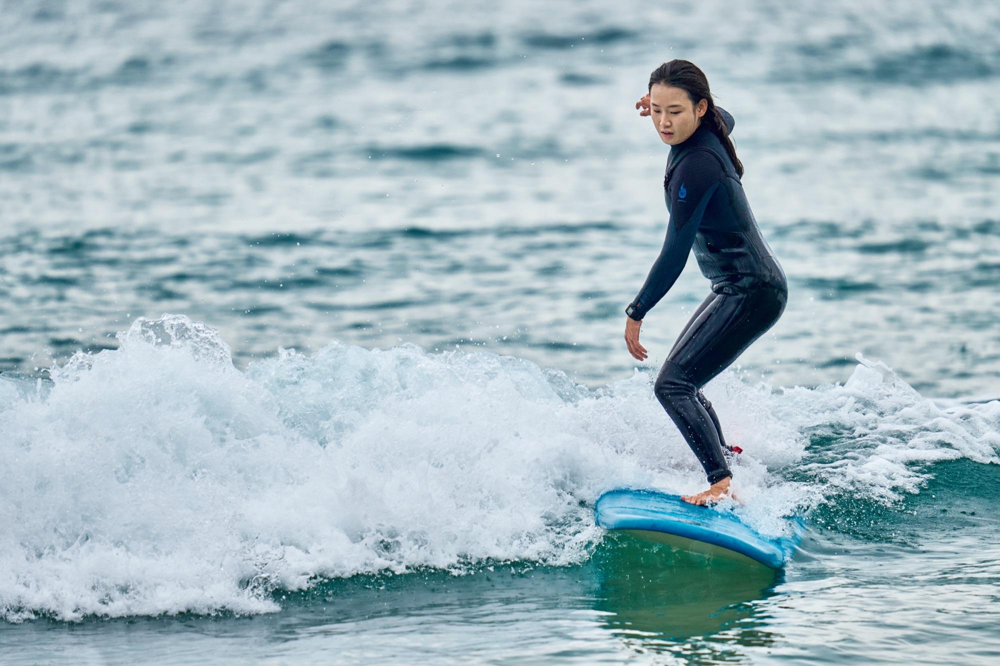 Beginner surfers learning on a Yangyang beach in Korea with instructors