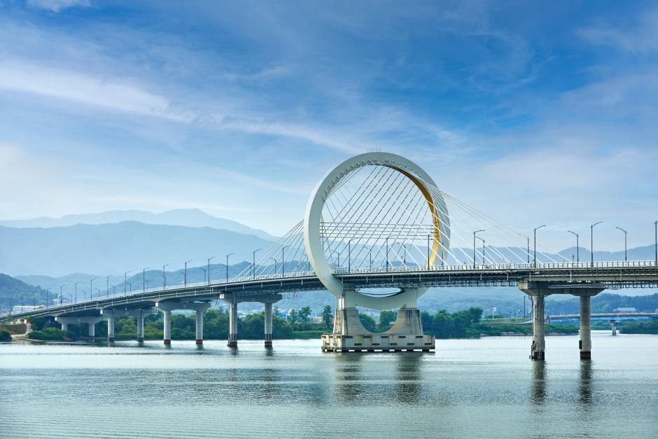 Chuncheon Bridge spanning the Soyang River with forested mountains and the calm reservoir waters in the background
