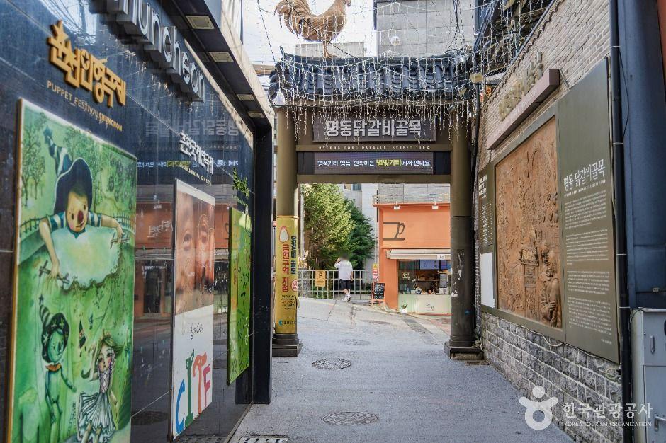 Chuncheon Myeongdong Street with colorful restaurant signs and pedestrians — the heart of the city's dakgalbi district