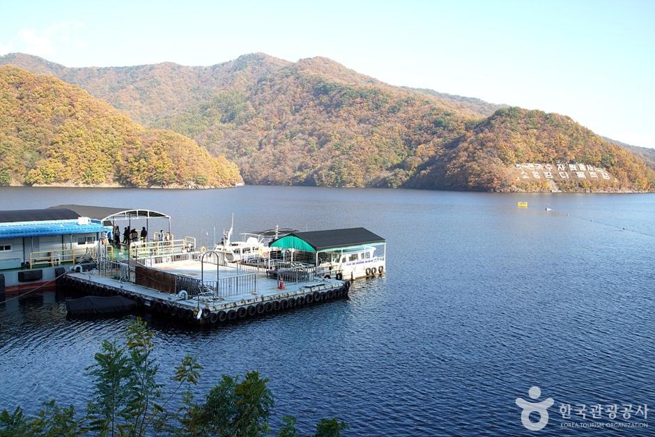 A ferry boat on the emerald-green Soyang Lake surrounded by forested mountains — the scenic cruise from Soyang Dam toward Cheongpyeongsa Temple