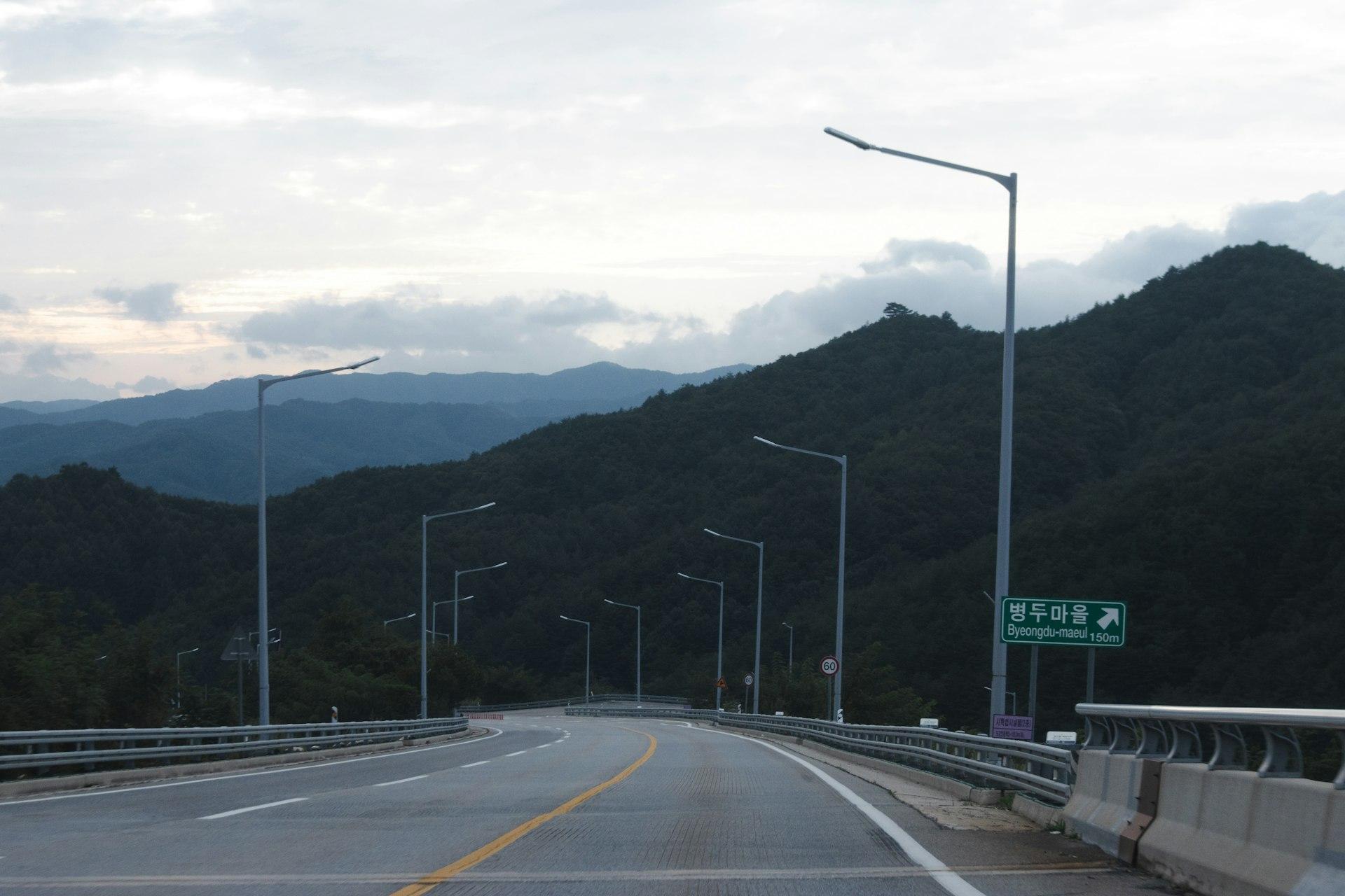 Empty highway winding through green forested mountains in Korea