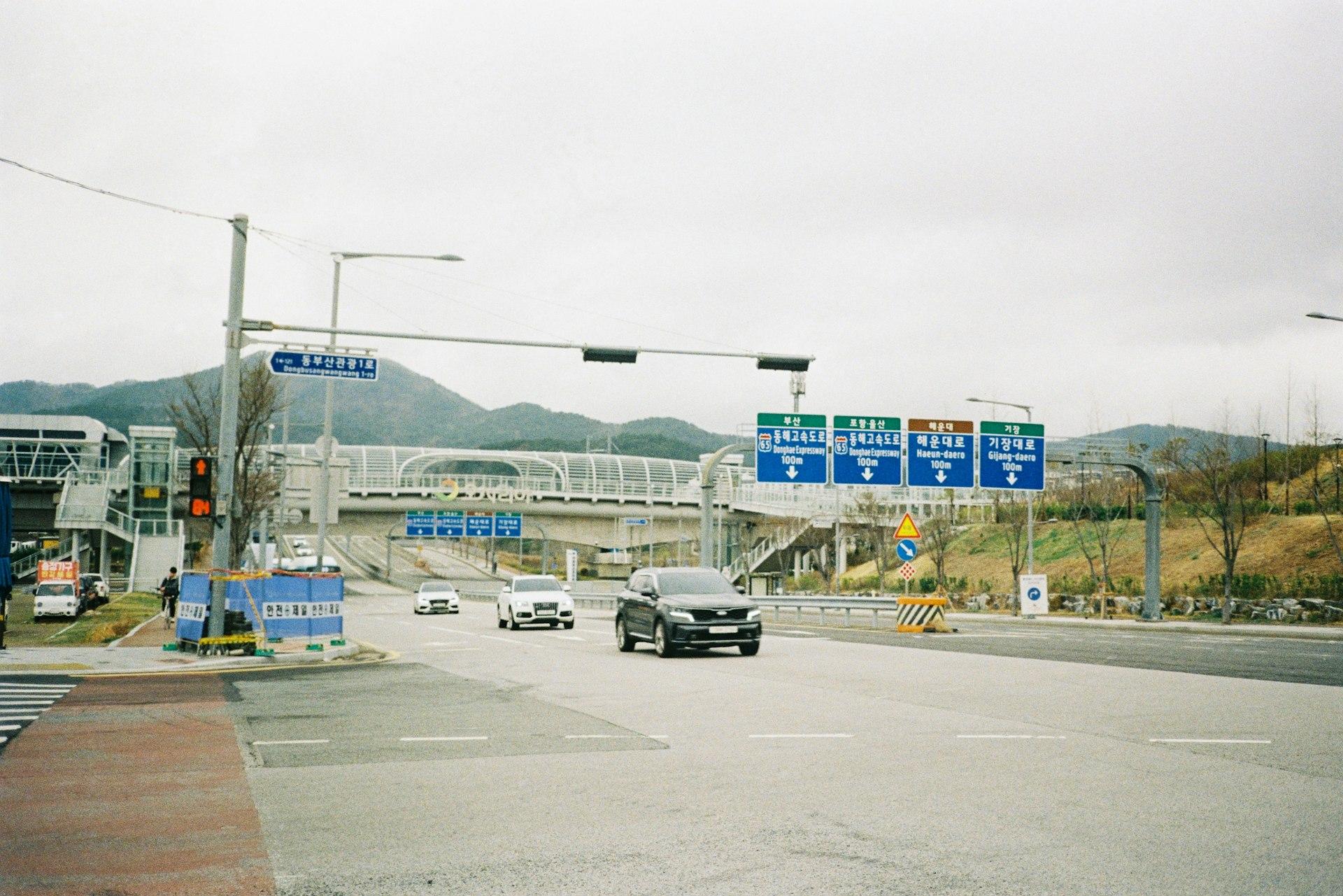 Cars traveling down a Korean expressway with directional signage overhead