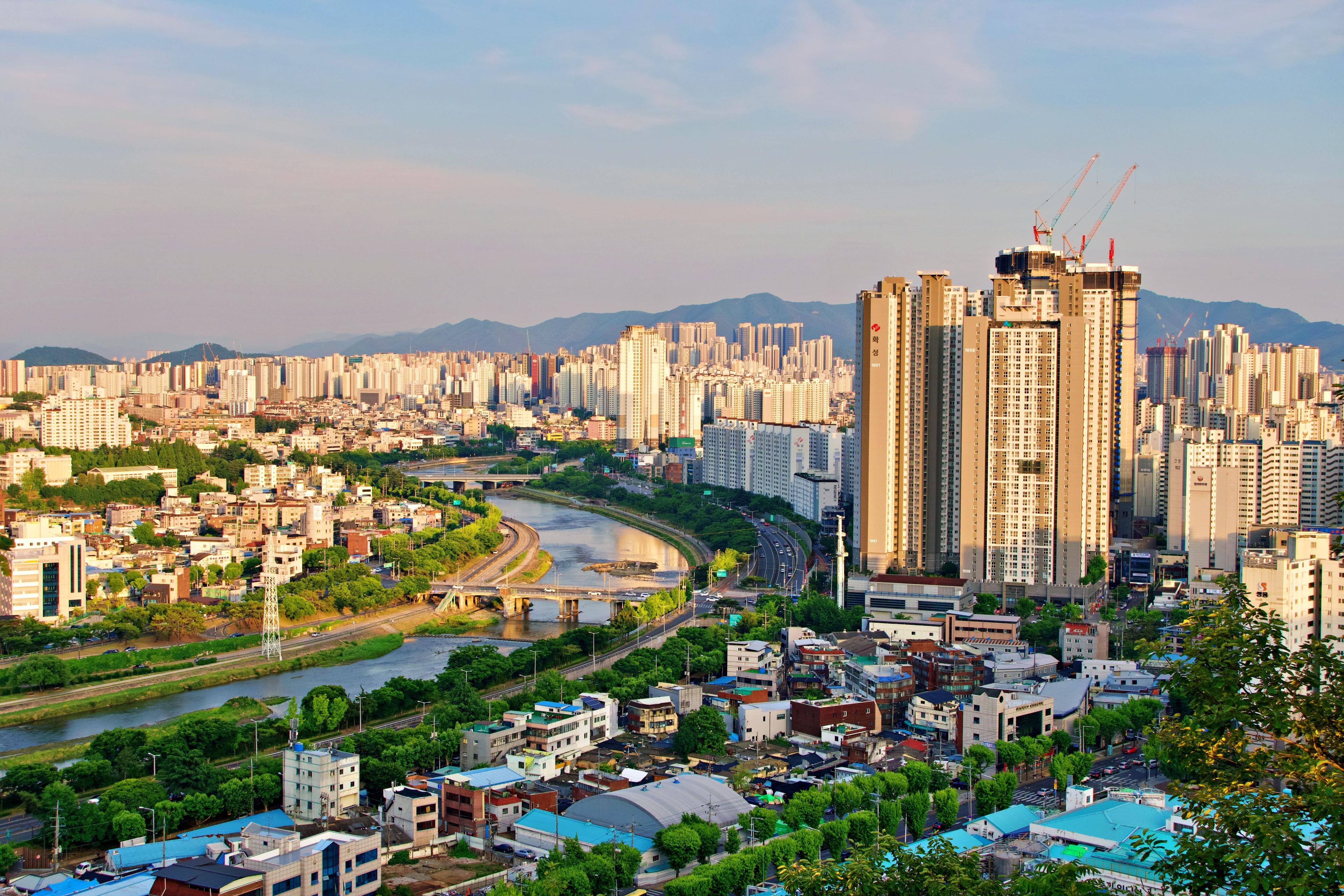 Daegu cityscape with forested mountains rising in the background in South Korea