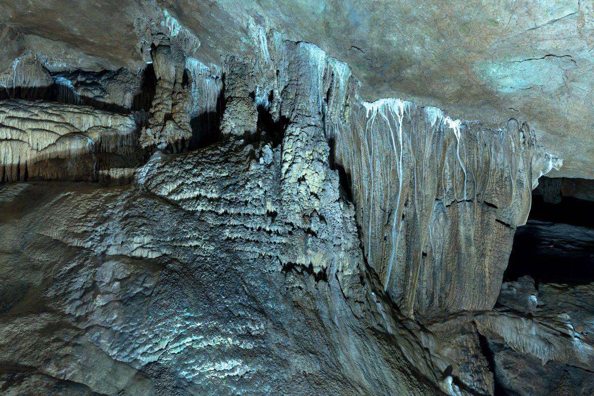 Illuminated stalactites and stalagmites inside a spectacular limestone cave