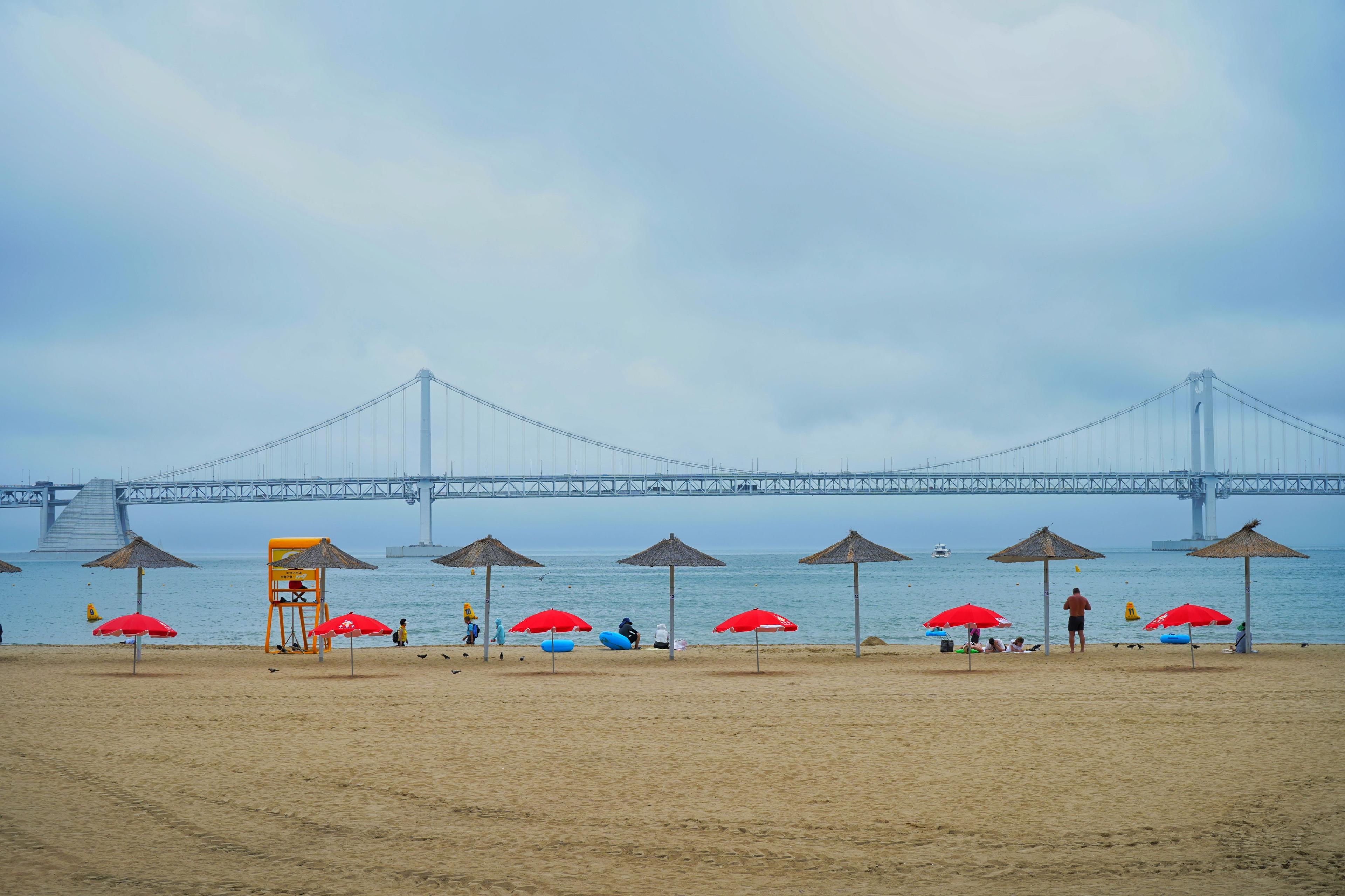 Gwangalli Beach in Busan, South Korea, with Gwangan Grand Bridge in the background on a clear summer day