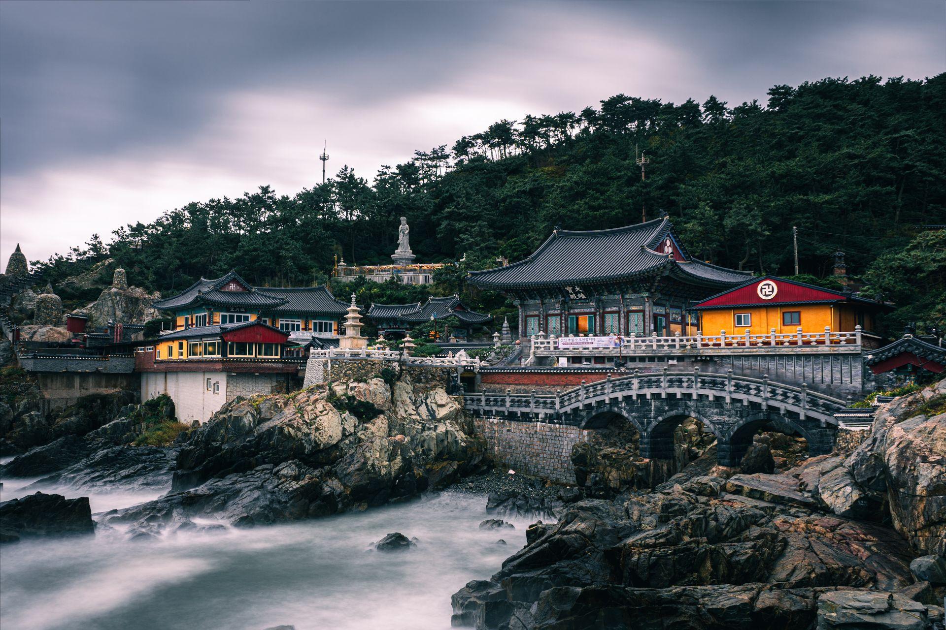Sunrise over the East Sea viewed from Haedong Yonggungsa Temple in Busan, with golden light on the pagoda