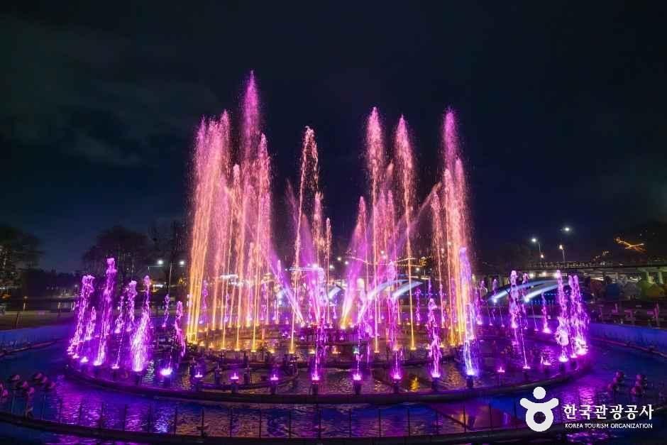 Jinju Nam River musical fountain with evening lights reflecting on the water