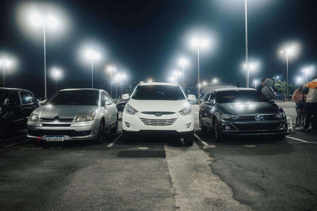 Cars parked at a rental return parking lot at night
