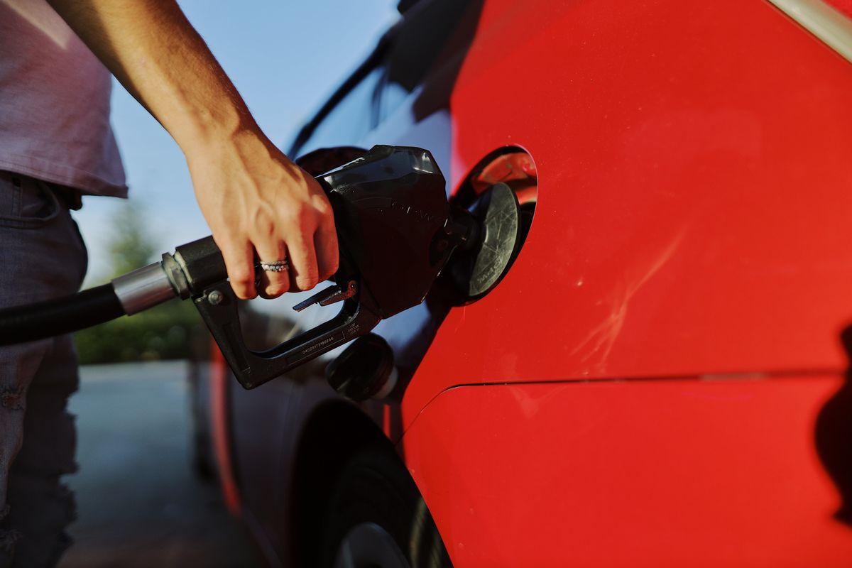 Person refueling a car at a gas station before returning a rental in Korea