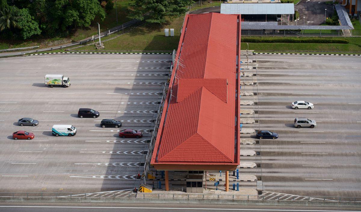 Aerial view of a busy highway toll plaza with multiple lanes of cars and trucks — similar to Korea's expressway toll system