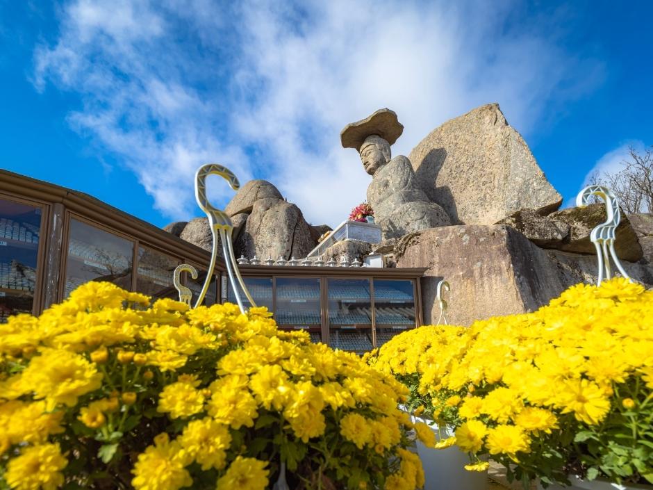 Gatbawi stone Buddha carved into a cliff face at the summit of Palgong Mountain, Korea