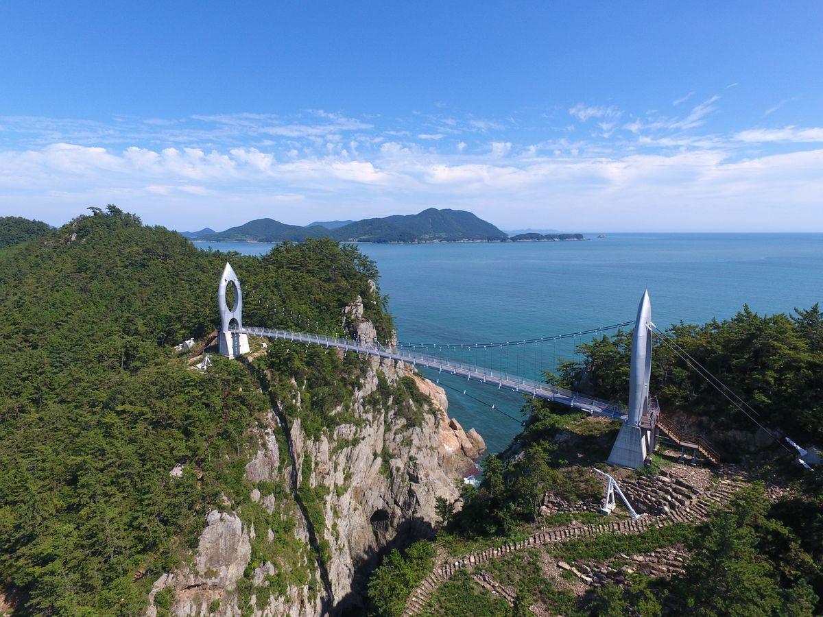 Coastal footbridge connecting Korean islands above the sea with lush green hills