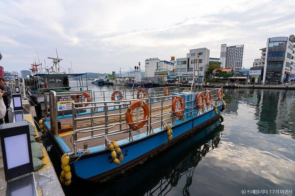 Gaetbae ferry docked at Dongmyeong Port with the Sokcho city skyline and bridge in the background